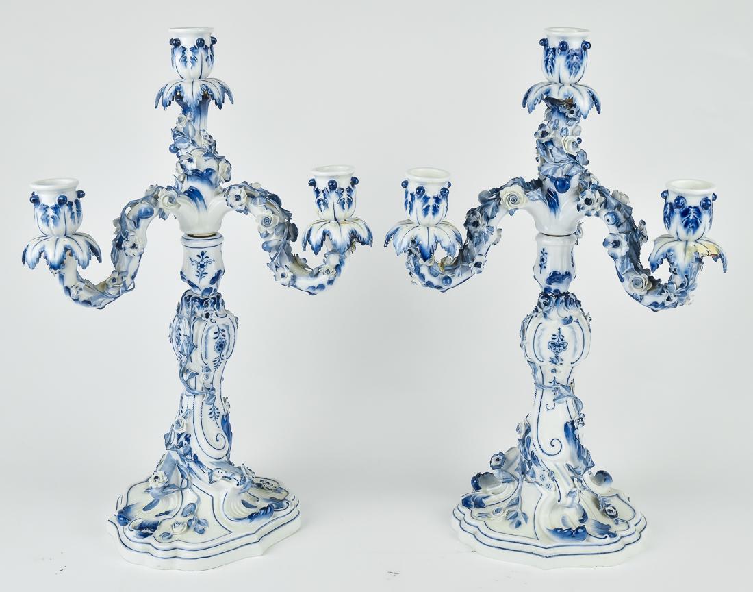 Pair Of Meissen Porcelain Candelabra: Three arm with central taller candle-socket, applied floral decoration with blue floral painting, two piece in rococo style, blue underglaze crossed sword mark, 9" diameter x 16 1/2" high.