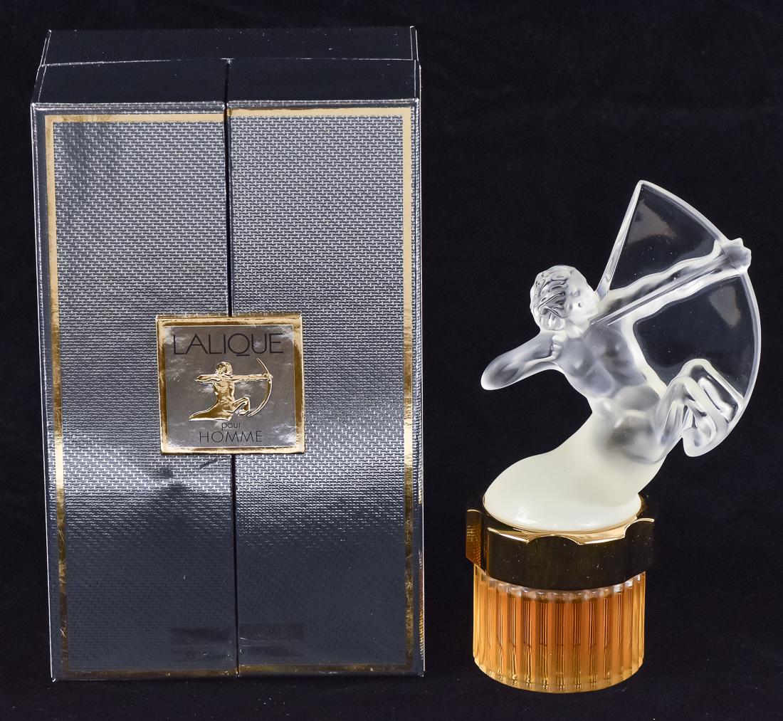 Lalique Perfume in Case: Labeled Lalique Pour Homme Eau De Parfum, with frosted centaur lid and full fluted bottle with printed label on base and gold mount, includes atomizer, bottle is 8" high, gray foil covered case is 5 3