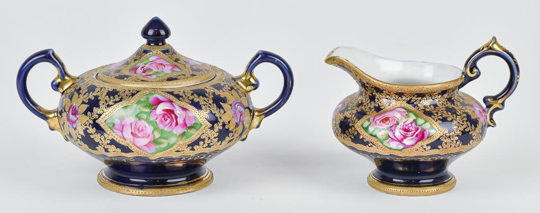 Nippon Cobalt Blue Creamer & Sugar: Lovely fold work with rose decoration. RC Noritake Nippon backstamp. 4 1/4" high x 7" wide. Tiny chip to underside of lid otherwise good condition.