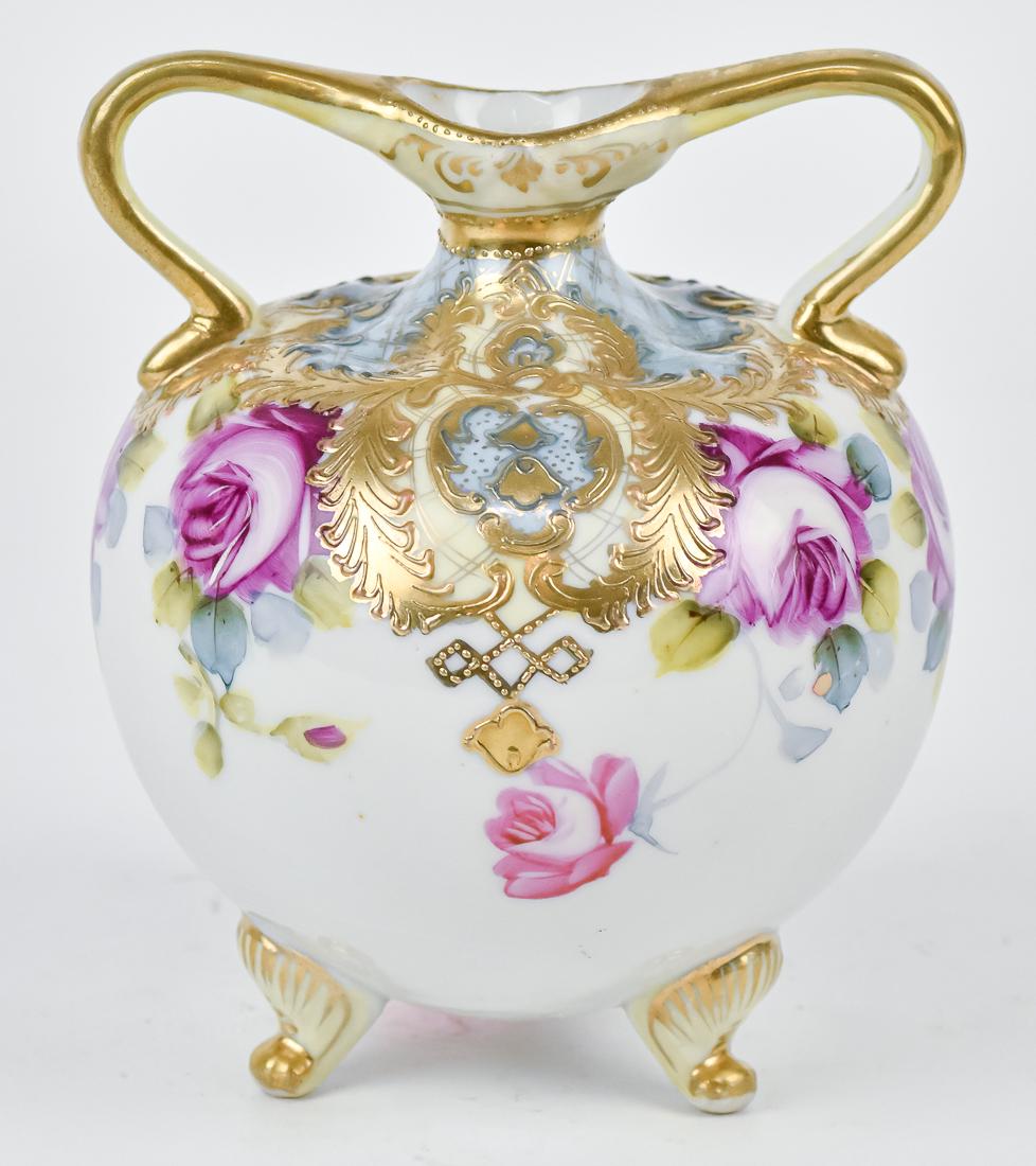 Nippon Double Handled Three Foot Vase: With floral and gold decoration. 5 3/4" High. Maple leaf Nippon backstamp. Fine Condition.