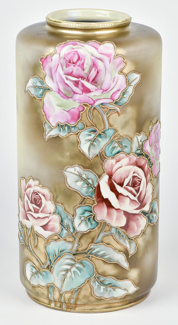 Large 15 1/4" Nippon Cylinder Vase: Decorated with colorful roses, with all edges decorated with heavily raised gold beads. Maple leaf Nippon backstamp. 15 1/4" High. Factory drilled for lamp on bottom side, a few pieces of decoration l
