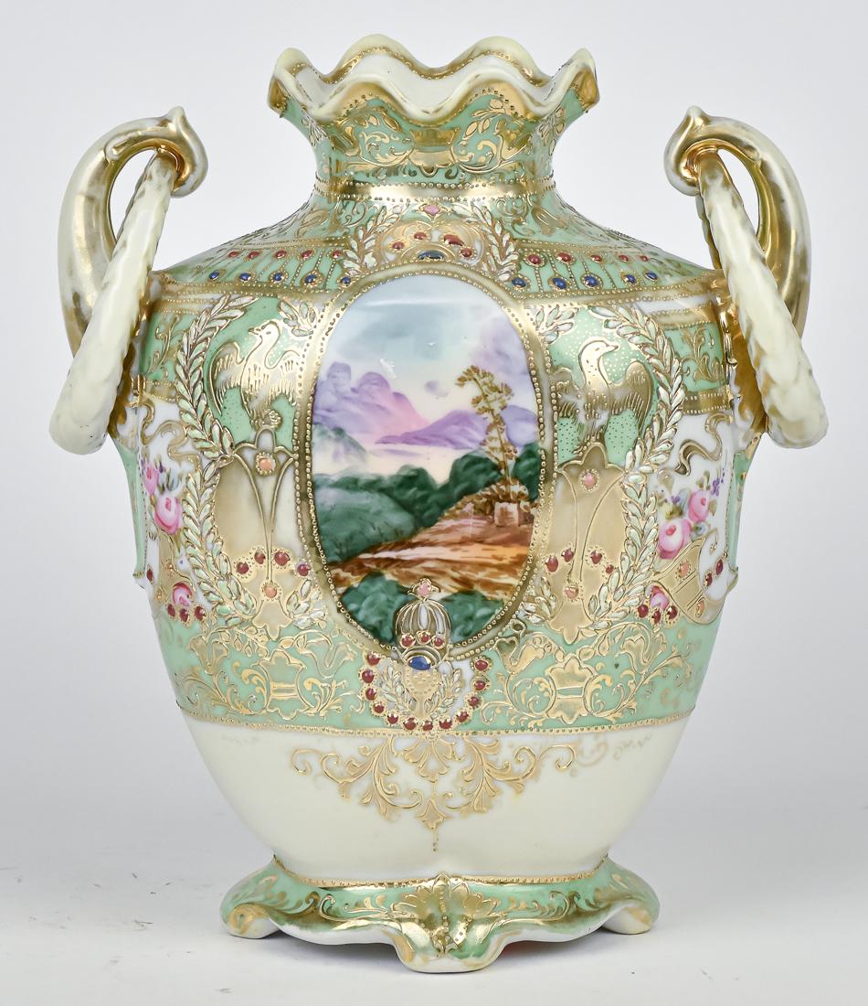 Nippon Scenic Vase With Beaded Jewels: Double ring handles, oval scenic panels surrounded by heavy gold and beaded jewel decoration. 9 1/2" High. Maple leaf Nippon backstamp. Wear to gold on handles, otherwise good condition.