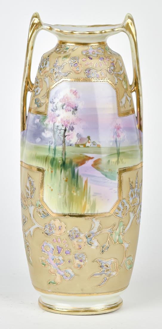 Large 13" Nippon Double Handled Vase: Hand painted home with stream scene on front and landscape on verso between raised and beaded gold decoration. M in wreath backstamp, 13" High. Good condition.