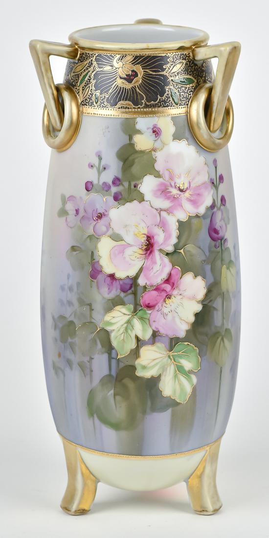 Nippon Vase with Loop Handles: Floral decorated & tri-footed. M within wreath backstamp. 11 1/2" high. Light wear to gold at handles, otherwise good condition.