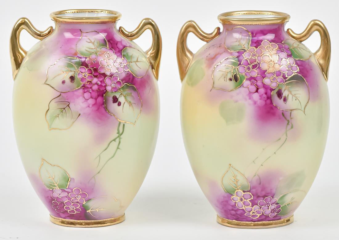 Pair of Nippon Hand Painted Vases: Double handled, with floral decoration and overall gold highlights. Maple leaf Nippon backstamp. 7 1/4" High. Good condition.