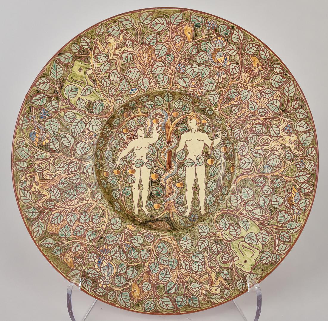 Artist Signed Sgraffito Decorated Charger: Decorated with Adam & Eve at tree with snake, background with vining leaves and animals around rim, red earthenware artist initialed on back, entwined HIS, 12 3/4" diameter. Condition Fine.