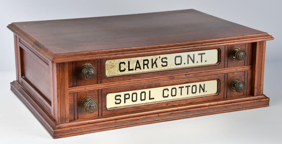 Clark's ONT Walnut Spool Cabinet: Two drawer with original gilt glass panels in drawer fronts, original knobs, completely full of old full to near full thread spools, 15 1/2 x 22 x 7 1/2" high. Condition Fine.