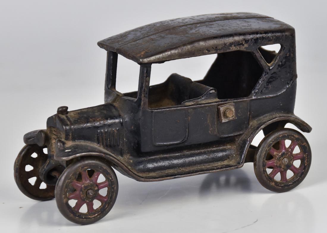 Arcade Ford Model T Toy: Cast iron in original black and red painted finish, convertible four door, unmarked, 6 1/4 x 3 x 4" high. Condition missing driver, paint circa 75%, replaced nut & bolt.