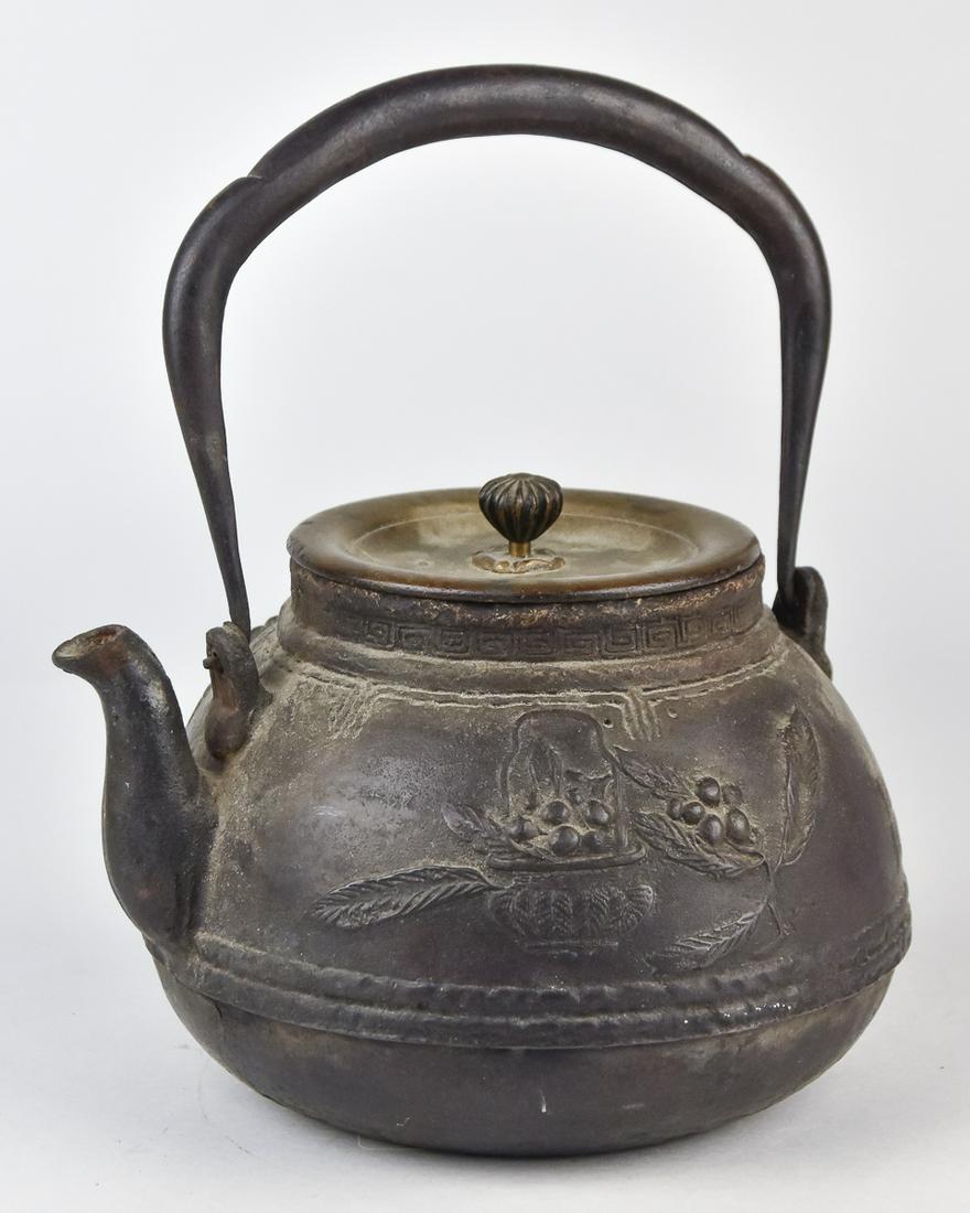 Meiji Cast Iron Tea Kettle: Decorated with high relief fruiting branches and butterflies and baskets, wrought iron swing handle and cast bronze lid with seed pod finial, marked with cast double seal on each side, fine old patina