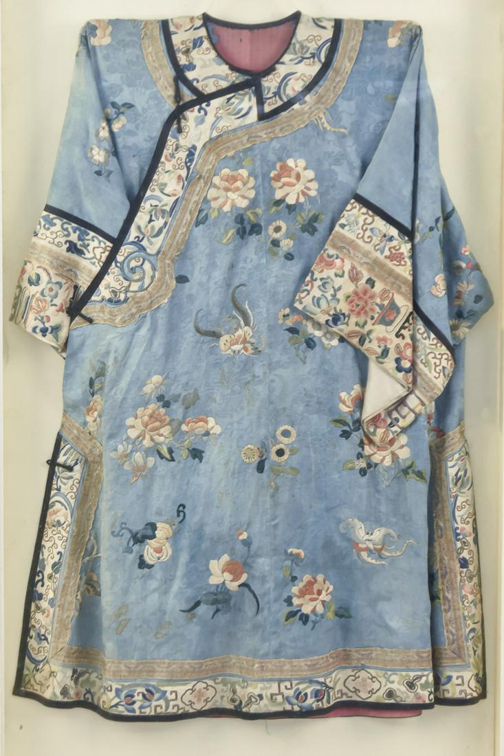 Chinese Embroidered Silk Robe: 19th century polychrome floral silk embroidery on light blue ground with wide white silk cuffs, all with floral embroidery, circa 30" wide x 35" long, mounted in plexi shadow box frame, so only front 