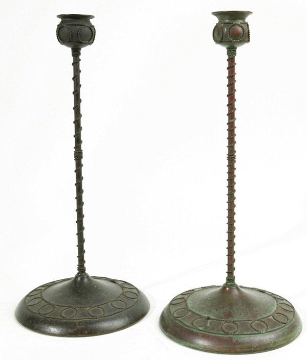 RIVIERE STUDIOS N.Y. BRONZE ARTS & CRAFTS CANDLEH: In the style of Tiffany with coiled rope designs. Very similar but not quite a pair. One is bronze and signed, the other one may be brass. Great old patina, one coil on base. As is. 15" h. EST. $250.