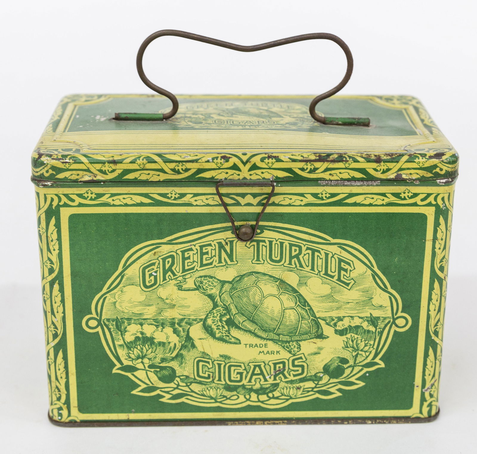 Green Turtle Cigar Tin: Chromolithographed tin with green sea turtle resting on rock and smoking cigar on front and hinged lid with wire bale handle, floral scroll surround, text panels on remaining sides including; Gordon C