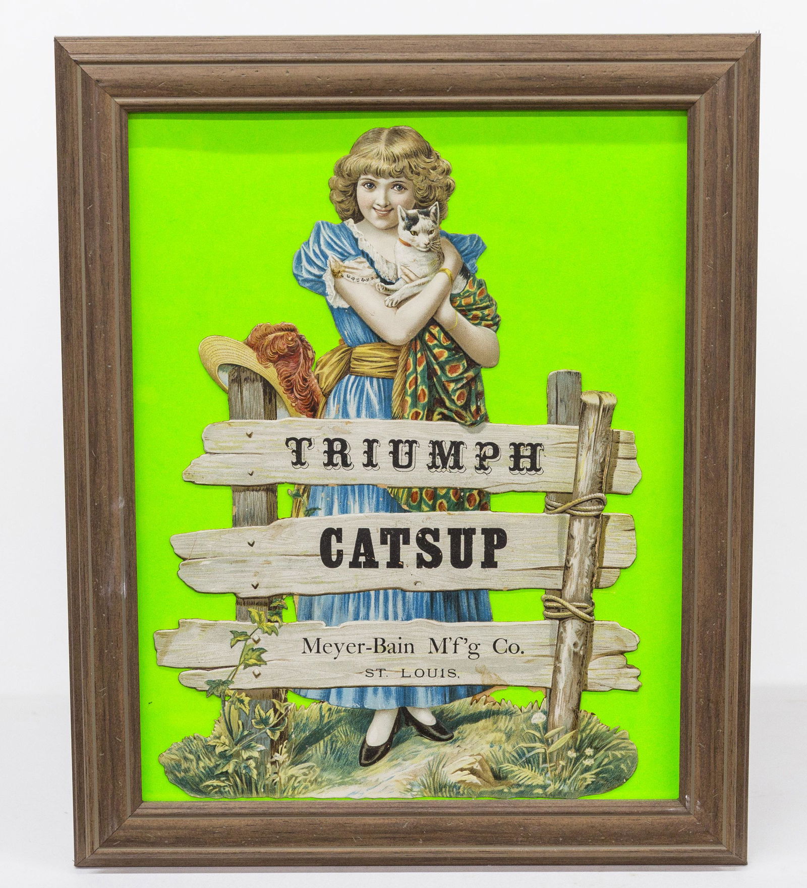 Triumph Catsup (sic) Die Cut: Young girl in blue dress holding cat at wood gate with slats in gate marked Triumph/Catsup/Meyer-Bai M'f'g Co./St. Louis, 9 1/4 x 13 1/2", pressure mounted and framed, 13 1/2 x 16 1/4". Condition Fine