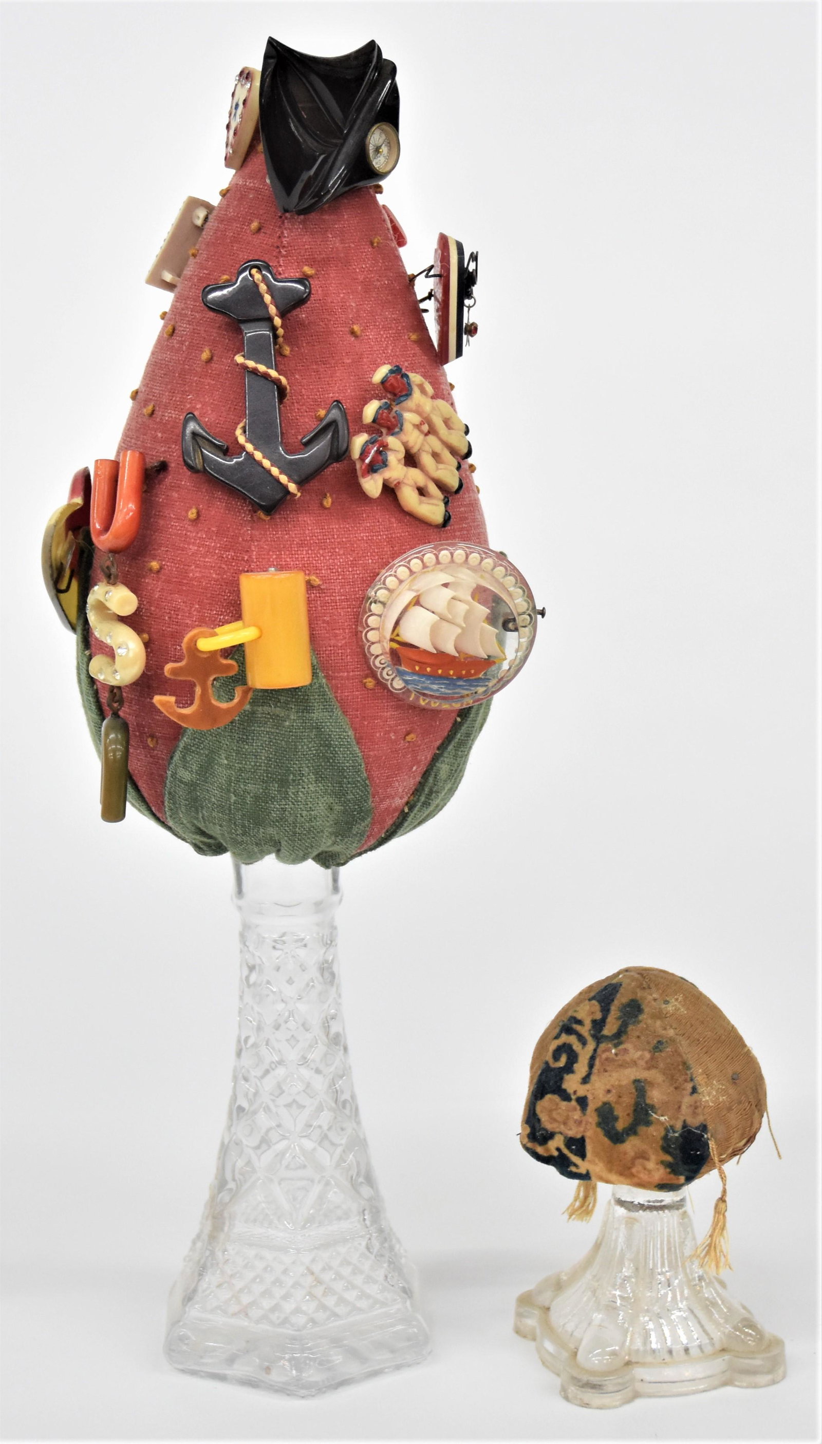 Two Make-Do Pin Cushions: 19th & early 20th century, each made using clear pressed glass base with smaller a lamp or candlestick base with added pin cushion top, 2 1/2" square x 4 1/2" high; and second made with vase as base a