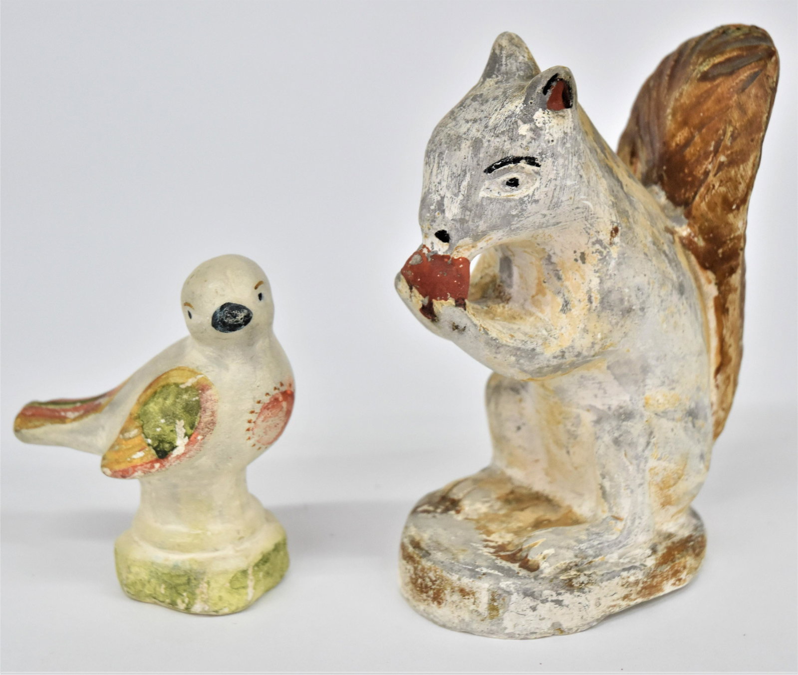 Early Chalkware Figures: Lot of two including a squirrel eating a nut, 4 1/2 x 2 1/2 x 5 3/4" high; and perching bird, 1 1/2 x 3 1/4 x 3 3/4" high. Both in original polychrome painted finish. Condition first with slight paint