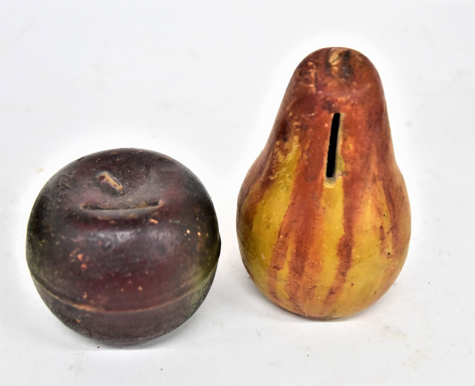 Polychrome painted Terra Cotta Fruit Banks: Lot of two 19th century American figural banks in original polychrome painted finish, apple and pear with coin slot at top and upper side, both with nice old patina, 2 3/4 & 4 1/2" high. Condition pai