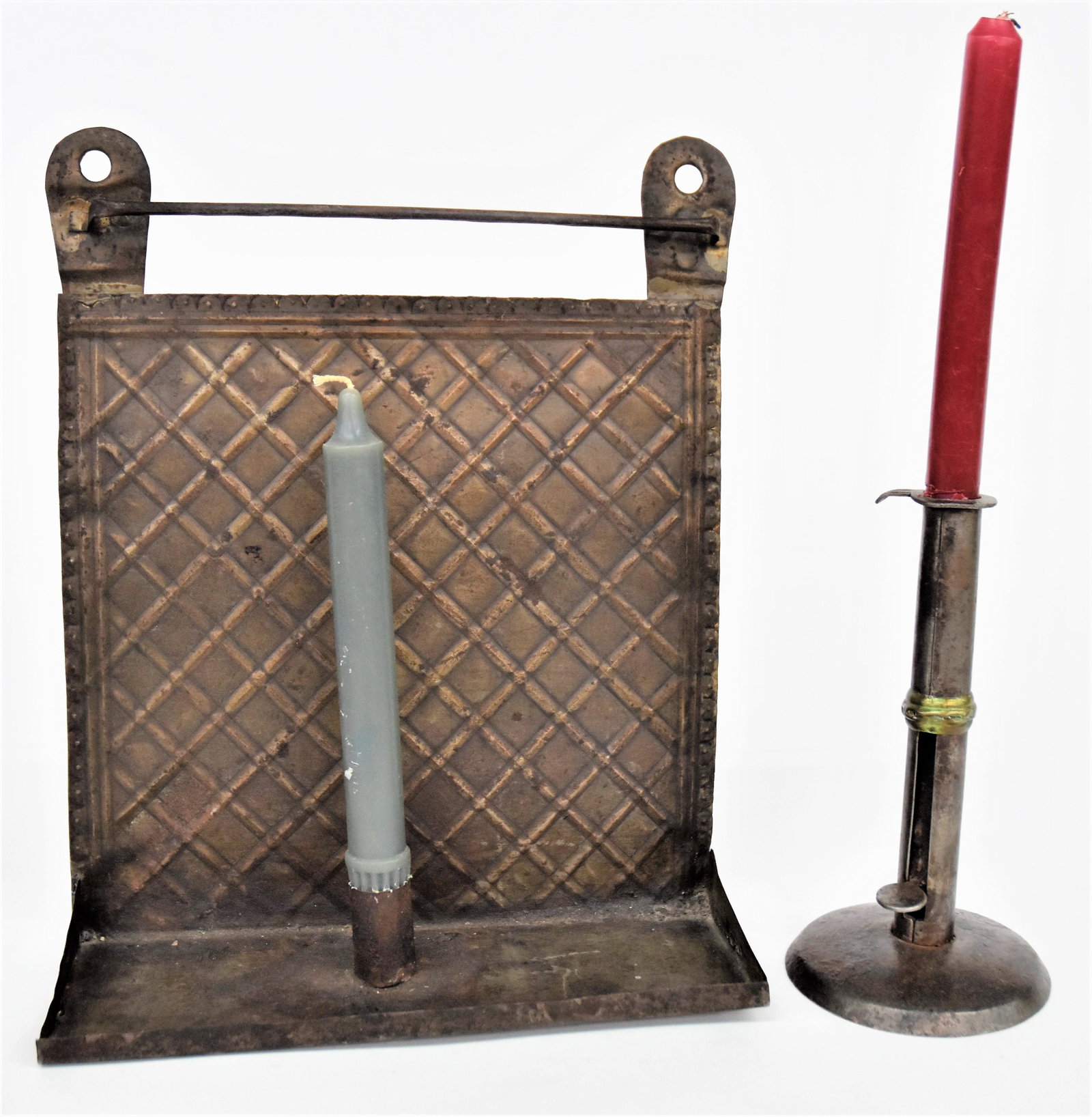 Early Signed Wrought Candlestick & Tin Candle Sconce: Lot of two including hog scraper type stick in wrought iron and brass, signed on thumb push-up SHAW, 4" diameter x 7 1/2" high; and stamped tin hanging candle shelf with checkerboard pattern, 10 x 3 3