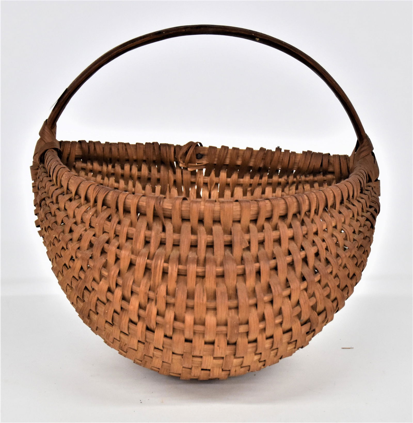 Early Half Buttocks Basket: Split hickory construction with bent hickory handle and half eye-of-God terminals at handles, nice old patina, 9 1/2 x 6 x 9" high. Condition Fine.
