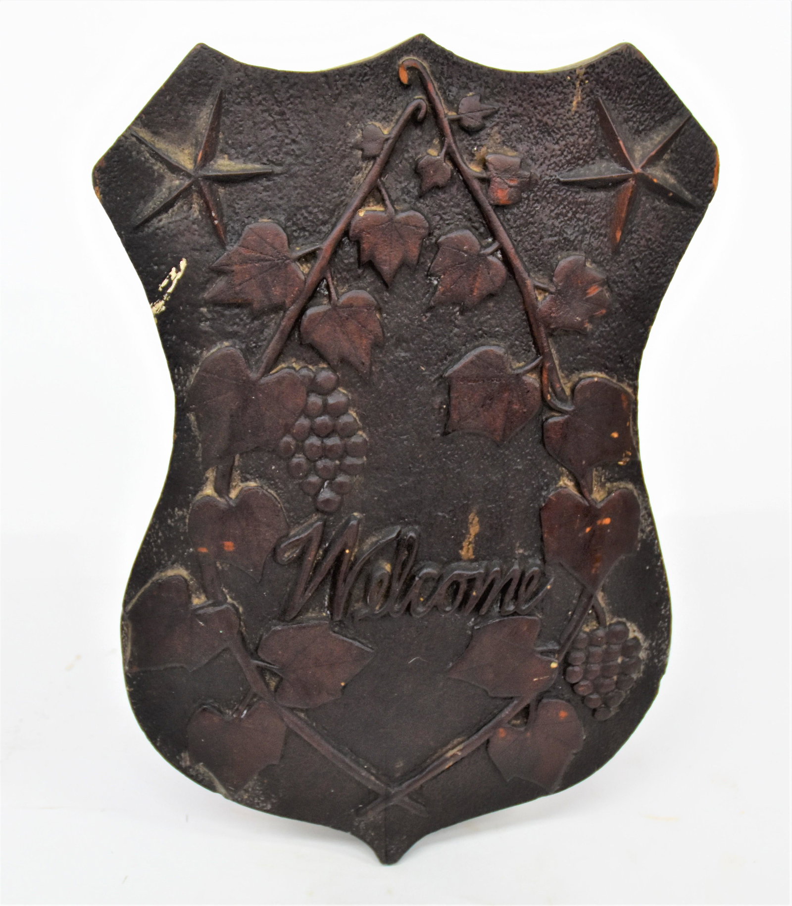 Signed Folk Art Carved Shield Escutcheon: Relief carved with crossed branches of grape leaves and fruit with Welcome in center and five-pointed stars above, in original old red varnish finish, with stippled ground. Signed and dated on back wi