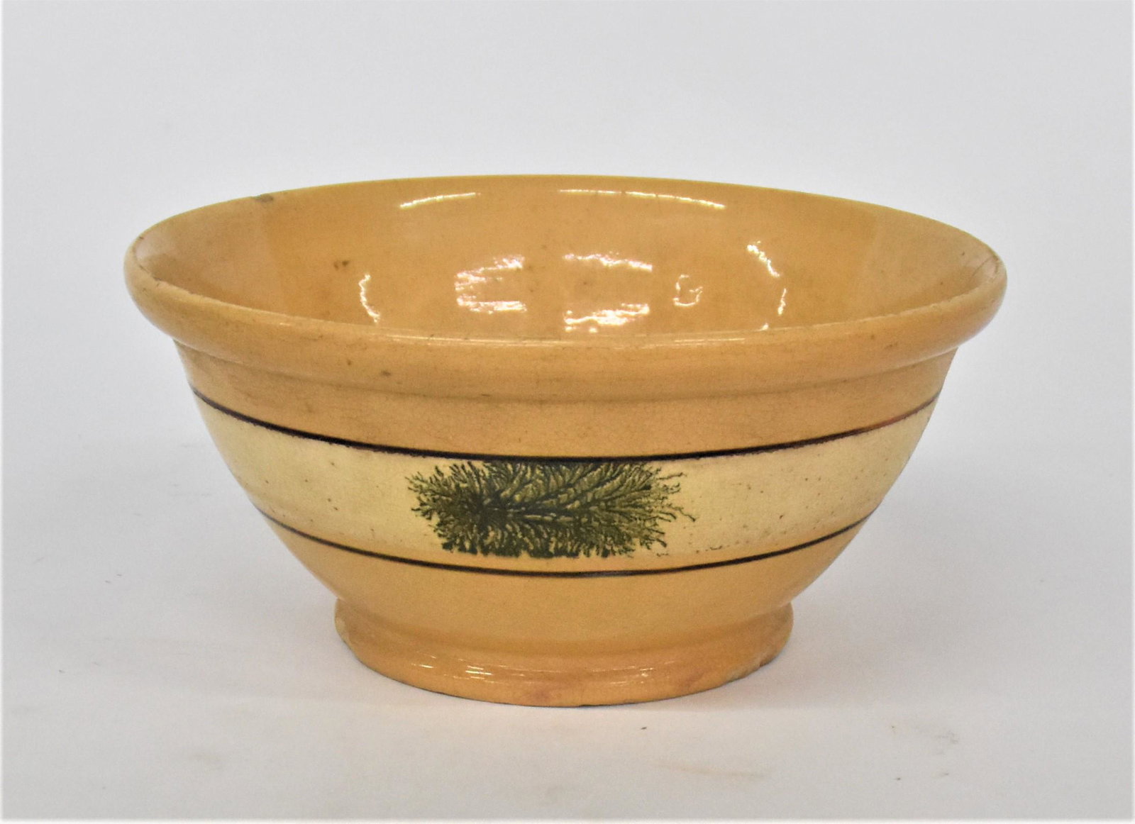 Covington Ky. Yelloware Bowl: Attributed to Wm. Bromley from his Covington Kentucky kiln, circa 1860, mixing bowl with thickened lip, decorated with slip trailed band with cream ground and green dendritic (sea weed) pattern, borde