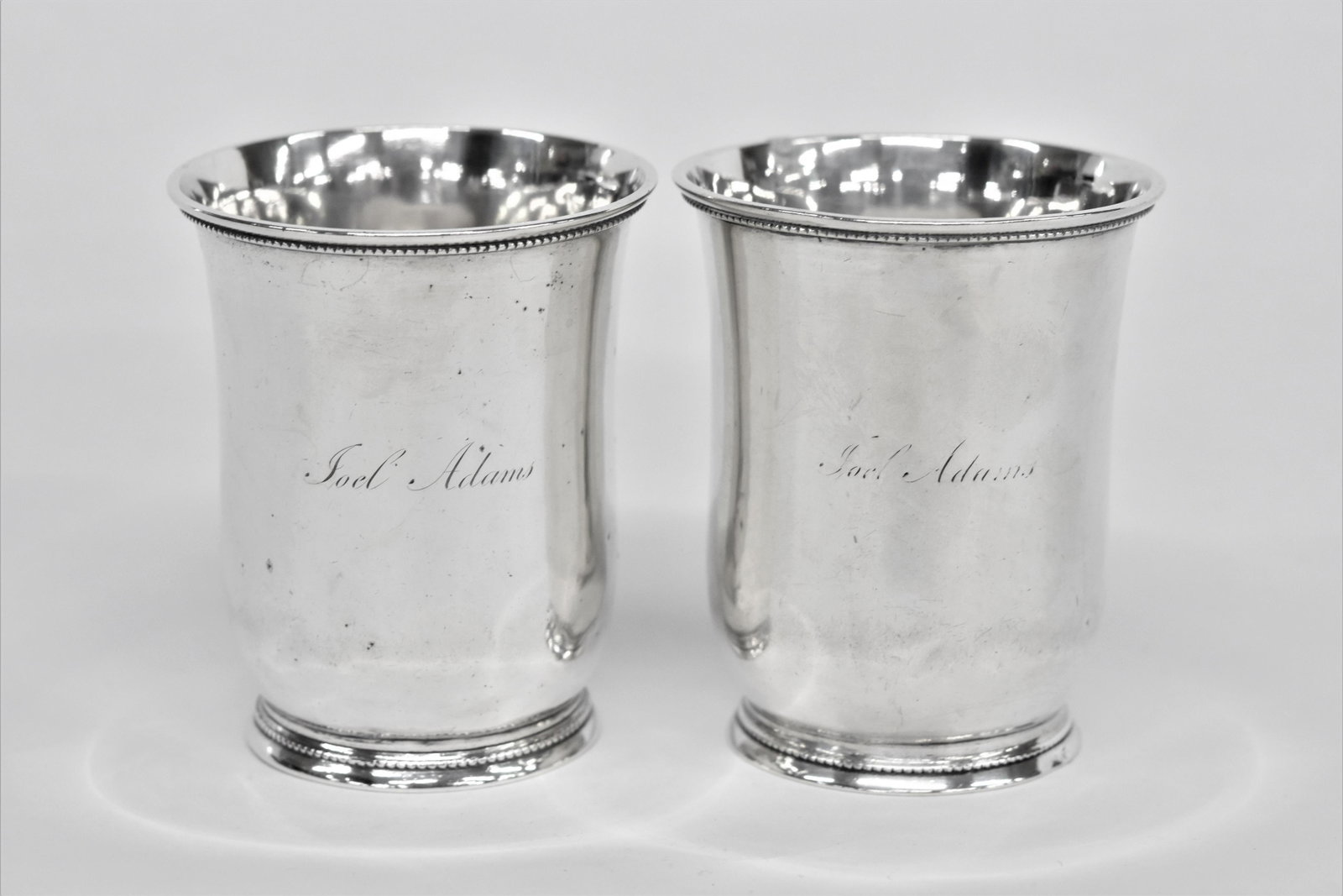 Pair Coin Silver South Carolina Julep Cups: Circa 1840's barrel form with beaded foot and rim, marked with rectangular touch mark with W. Glaze and 2nd vertical oval touch with W&H, engraved on front of each Joel Adams, 3 1/8 x 3 3/4" high, tot