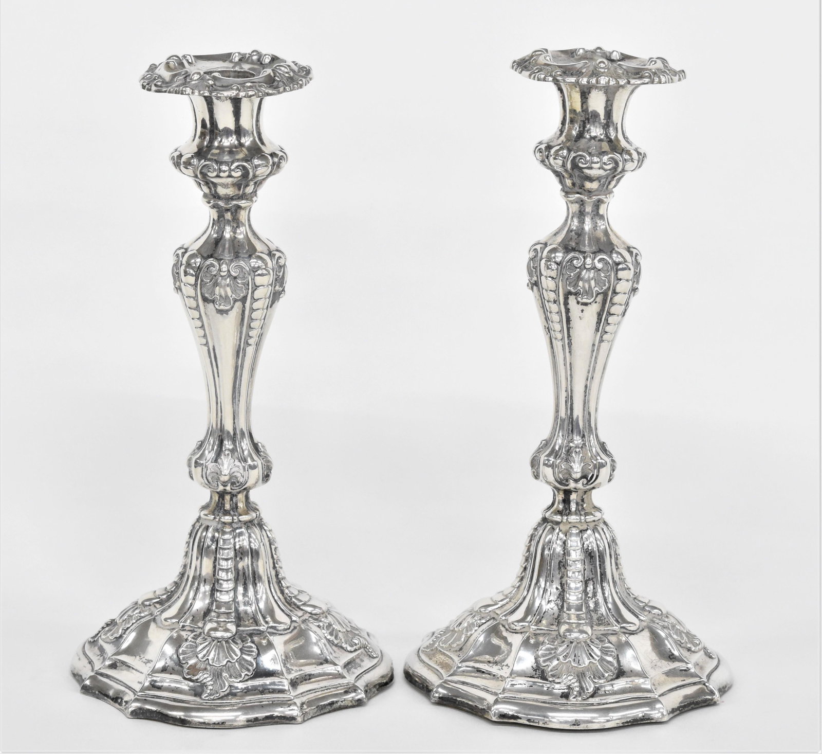 18th Century Sheffield Plate Candlesticks: Pair of rococo chased sticks with acanthus leaves, marked SH & Co. in rectangular touch mark on foot, resin filled, 10" high. Condition Fine.