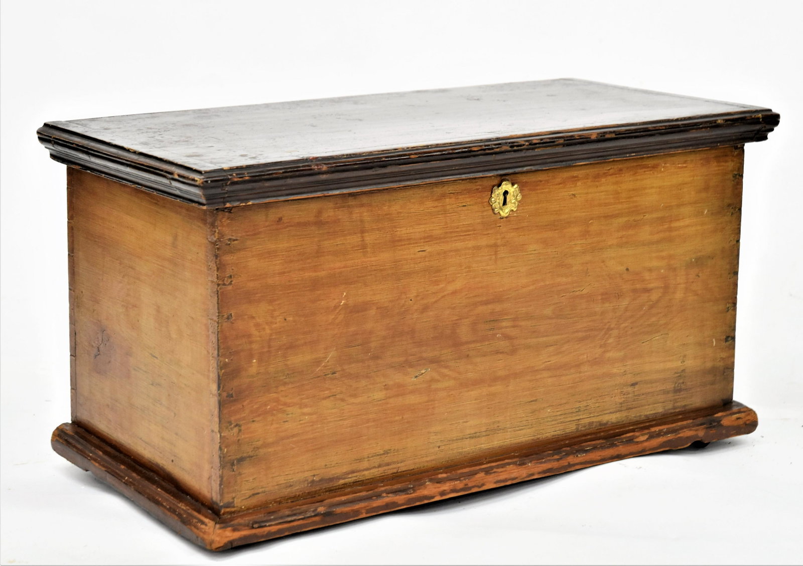 Paint Decorated Miniature Blanket Chest: Poplar with dovetailed case, cove molded overhanging lid with bread board ends in old brown paint, grain painted case and brown painted foot, brass escutcheon and early iron casters, 25 1/2 x 13 x 14"