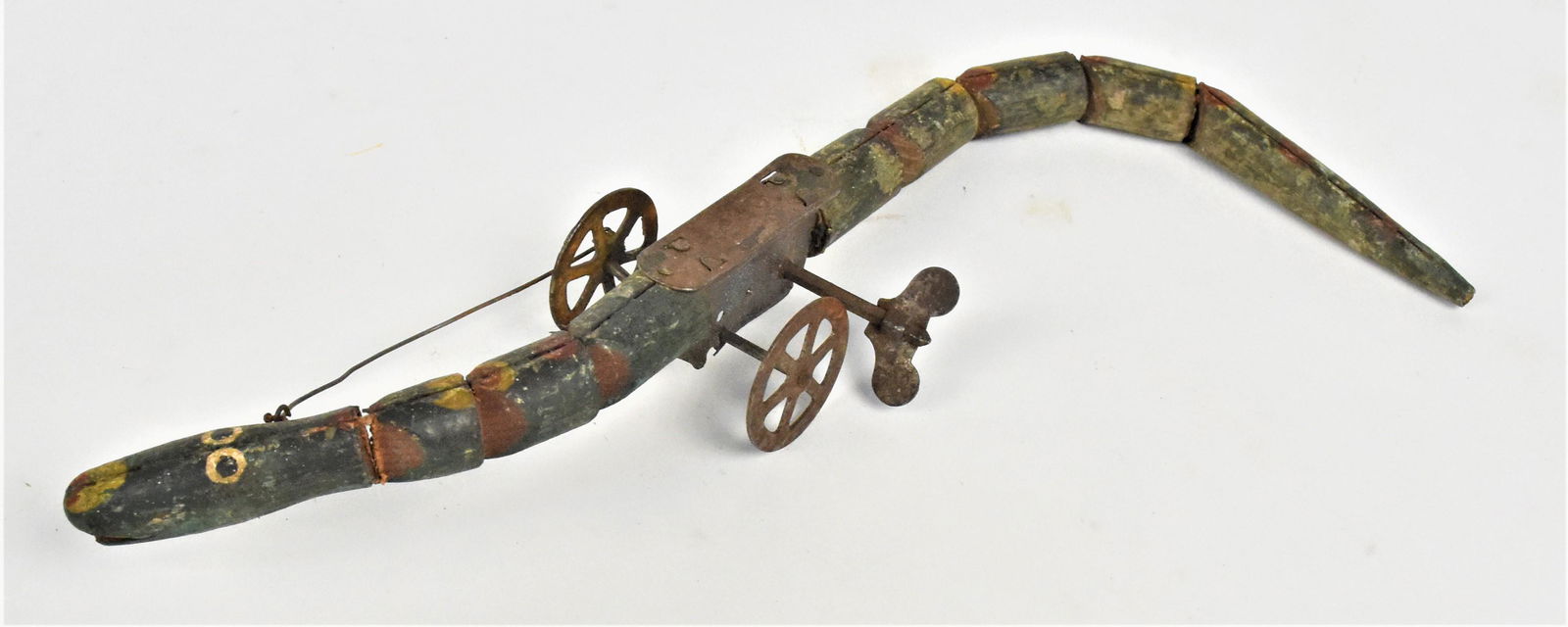 Folk Art Wind-Up Snake Toy: Circa 1880, American with polychrome painted wood segmented snake mounted on tin wheels with fixed key wind-up spring driven motor, 2 3/4" wide at mechanism x 13" long