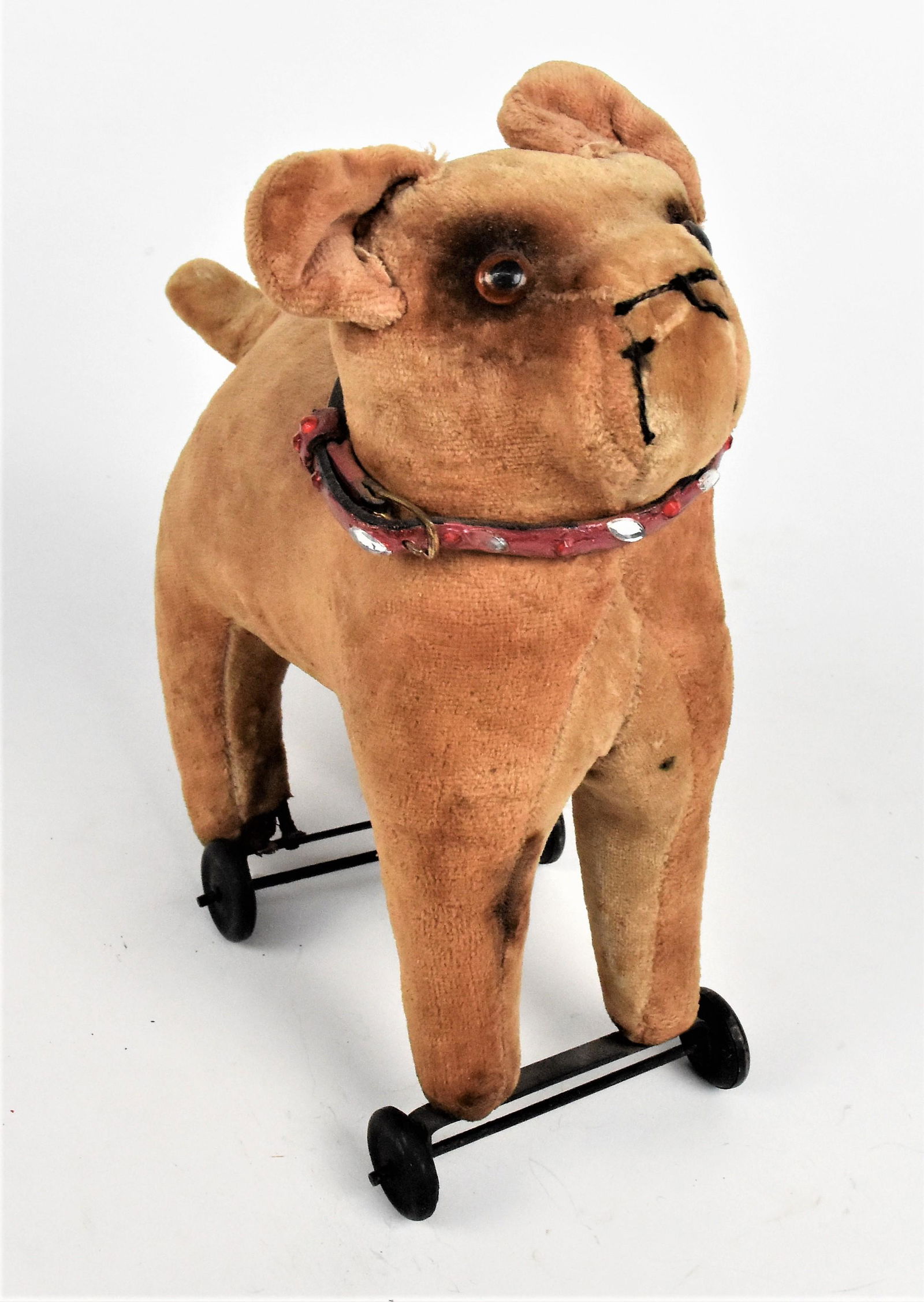 Bull Dog Pull Toy: Mohair with excelsior stuffing, glass eyes, thread sewn mouth and nose, jeweled collar on four hard rubber wheels, 9 x 4 x 10 1/2" high. Condition minor wear and slight stains, still Very Good.