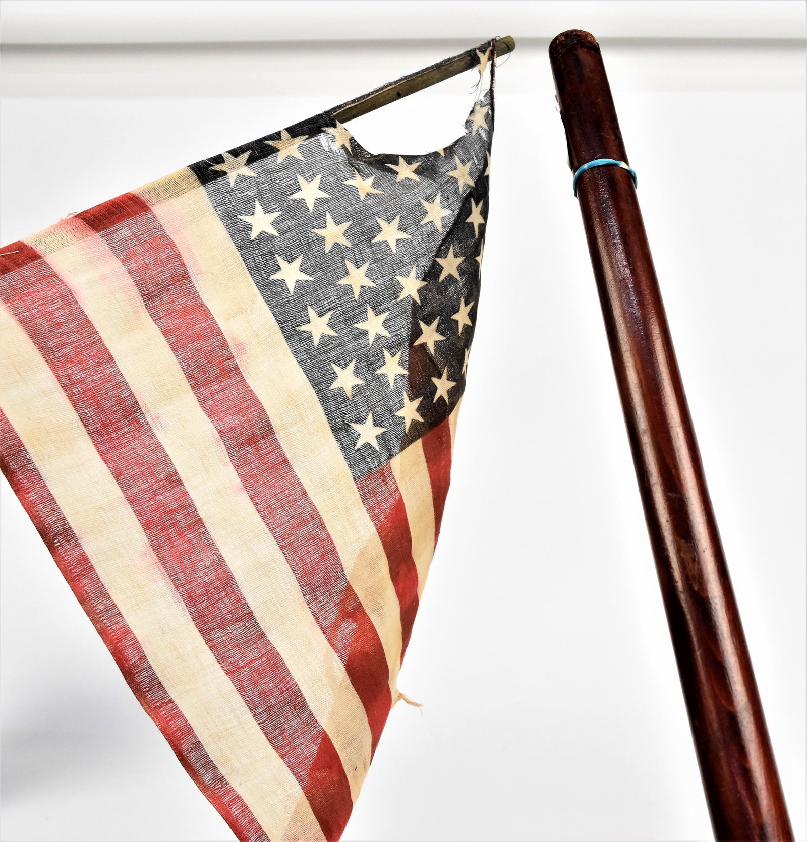 Walking Stick with 38 Star Flag: Tapered wood shaft with rond knob, attached to 38 star glazed cotton flag, circa 1876, in old varnish finish, total length 35 1/2". Condition flag some what fragile, else Fine.