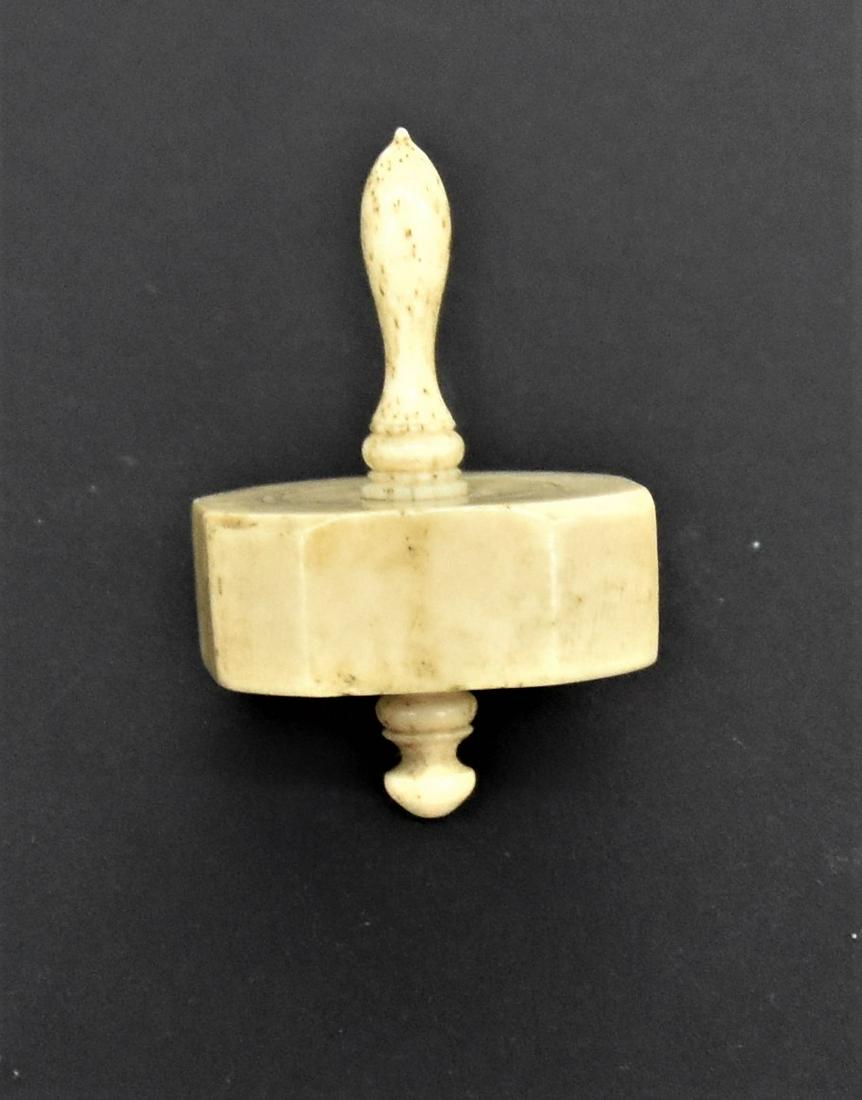 Scrimshaw Whale Bone Dreidel: American 19th century with eight sides and turned shaft, nice old patina, 1 1/8" diameter x 2" high. Condition Fine.