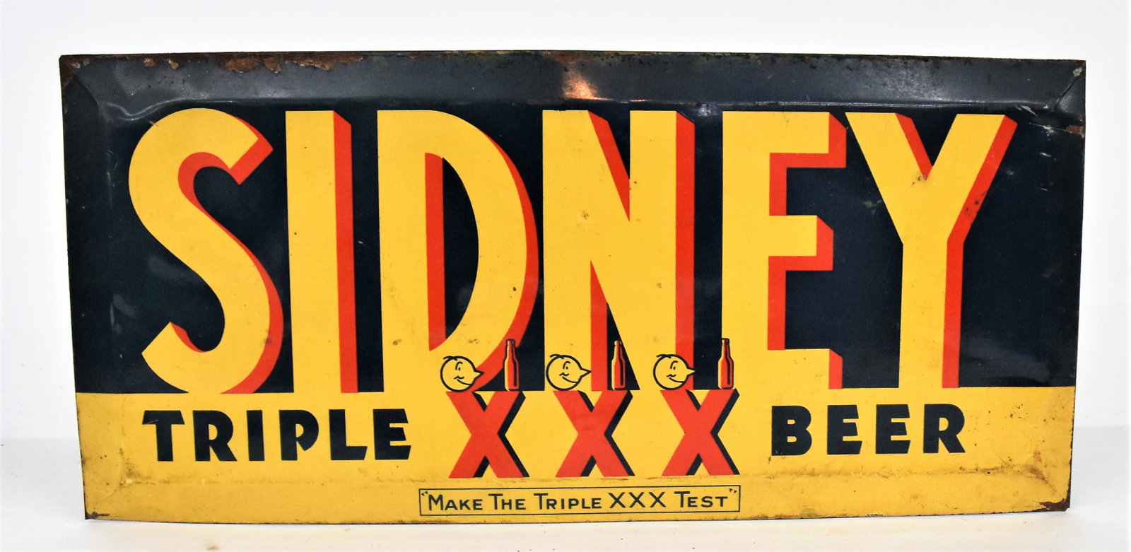 Sidney Beer Sign: Chromolithographed tin with Sydney/Triple XXX Beer/Make The Triple XXX Test, with card stock counter shelf folding prop on back, 13 x 6" high. Condition paint circa 95%, minor margin wear.