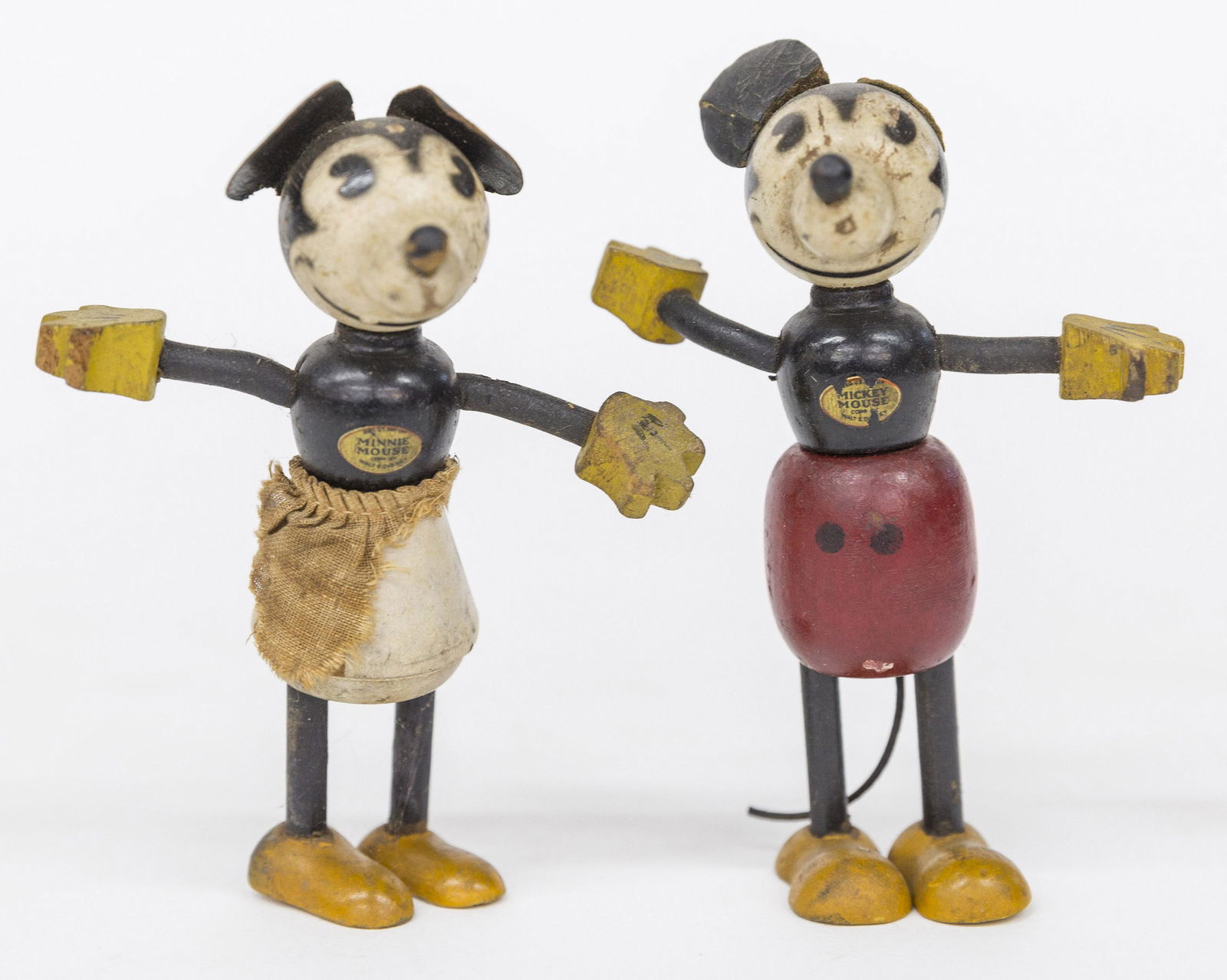 Early Wood Mickey & Minnie Mouse: Each with original gold & black decal with Mickey Mouse/Corp By Walt E. Disney and Minnie with same, original polychrome painted finish, card stock ears, Minnie with plaid apron, 4" high. Condition Mi