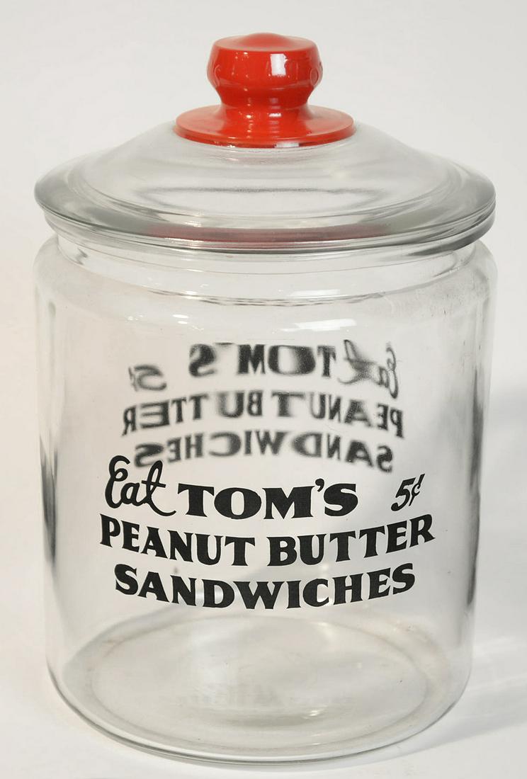 Tom's Peanut Butter Sandwich Jar: Counter top glass lidded jar with Eat Tom's 5?/Peanut Butter/Sandwiches on each side and red enameled knob on lid with embossed Toms, 9" diameter x 13" high. Condition near mint.