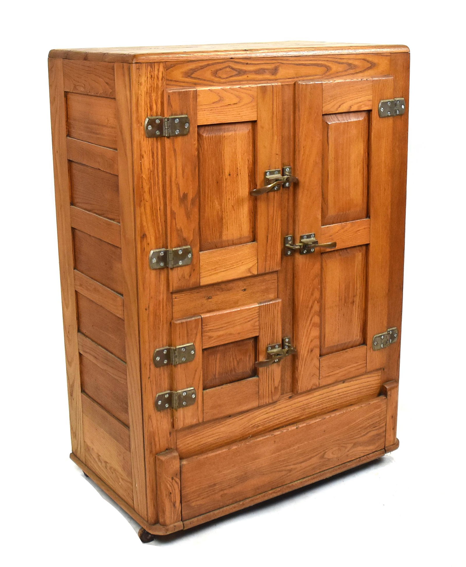 Oak Ice Box: Circa 1920-30's with three doors, all interior shelving, paneled ends, brass hardware on casters, 31 x 18 x 45" high. Condition Cleaned finish, else Fine.