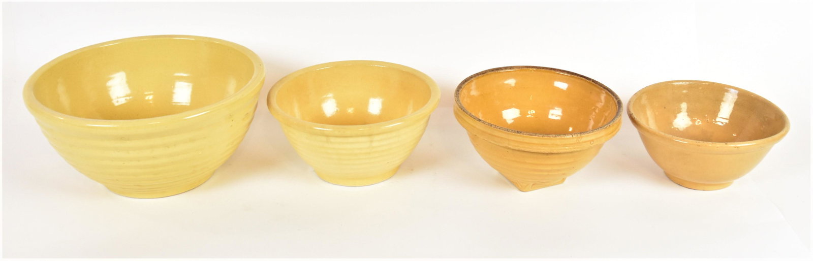 Four Yelloware Mixing Bowls: Smallest is 19th century and 9 1/4" diameter x 4 1/2" high; largest is 13 1/4" diameter x 6 1/2" high. Condition three smaller with tight lines, else Fine.