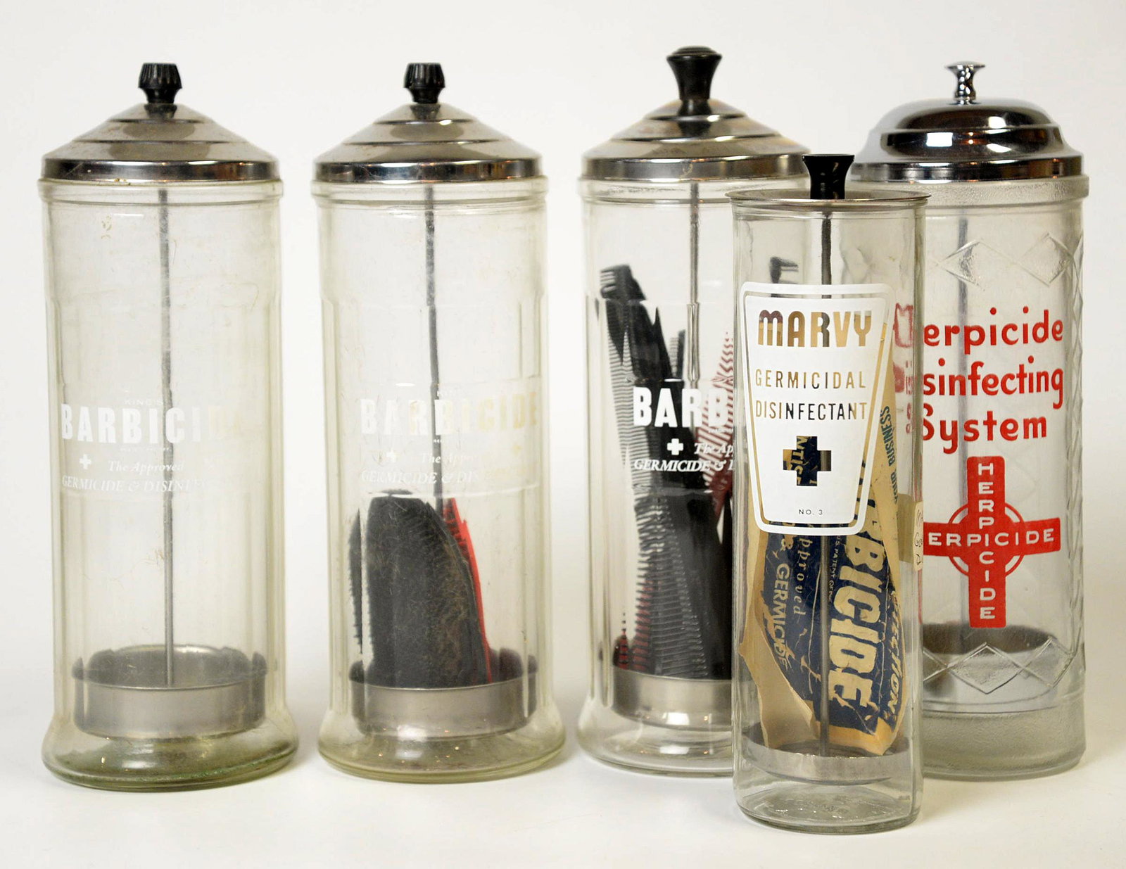 Five Barbers Comb & Brush Sterilizers: All clear pattern glass with chrome lids decals on fronts including three Barbicide The Approved Germicide Disinfectant, marked on bases King Research Inc. Glass Made In Canada, 4” diameter x 11” 