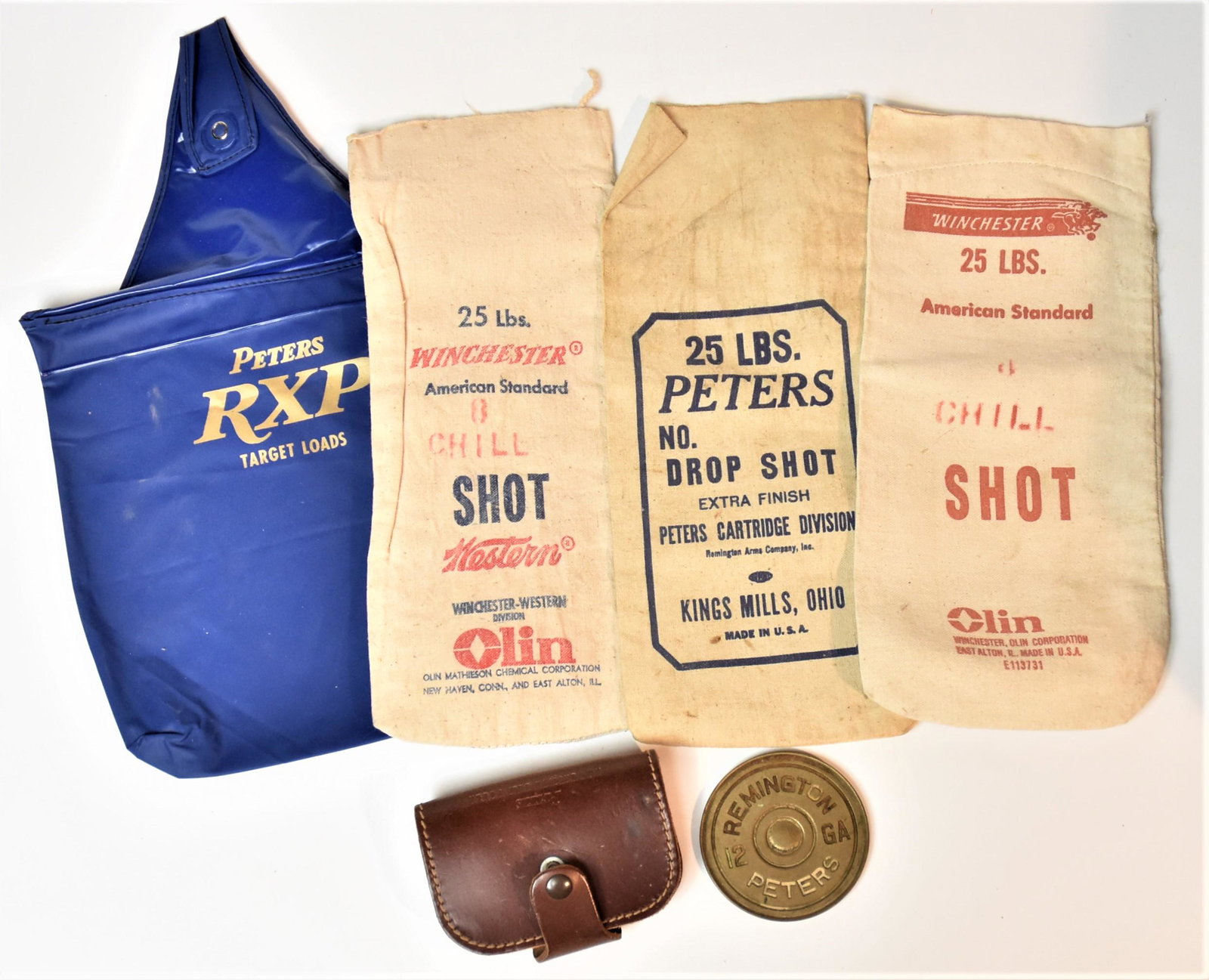 Peters & Remington Ephemera: Lot of six including brass paper weight in the form of base of Remington Peters 12 Ga shell, 3 3/8” diameter; plus brown leather belt pouch with snap closure stamped Peters Ammunition Belt Pouch