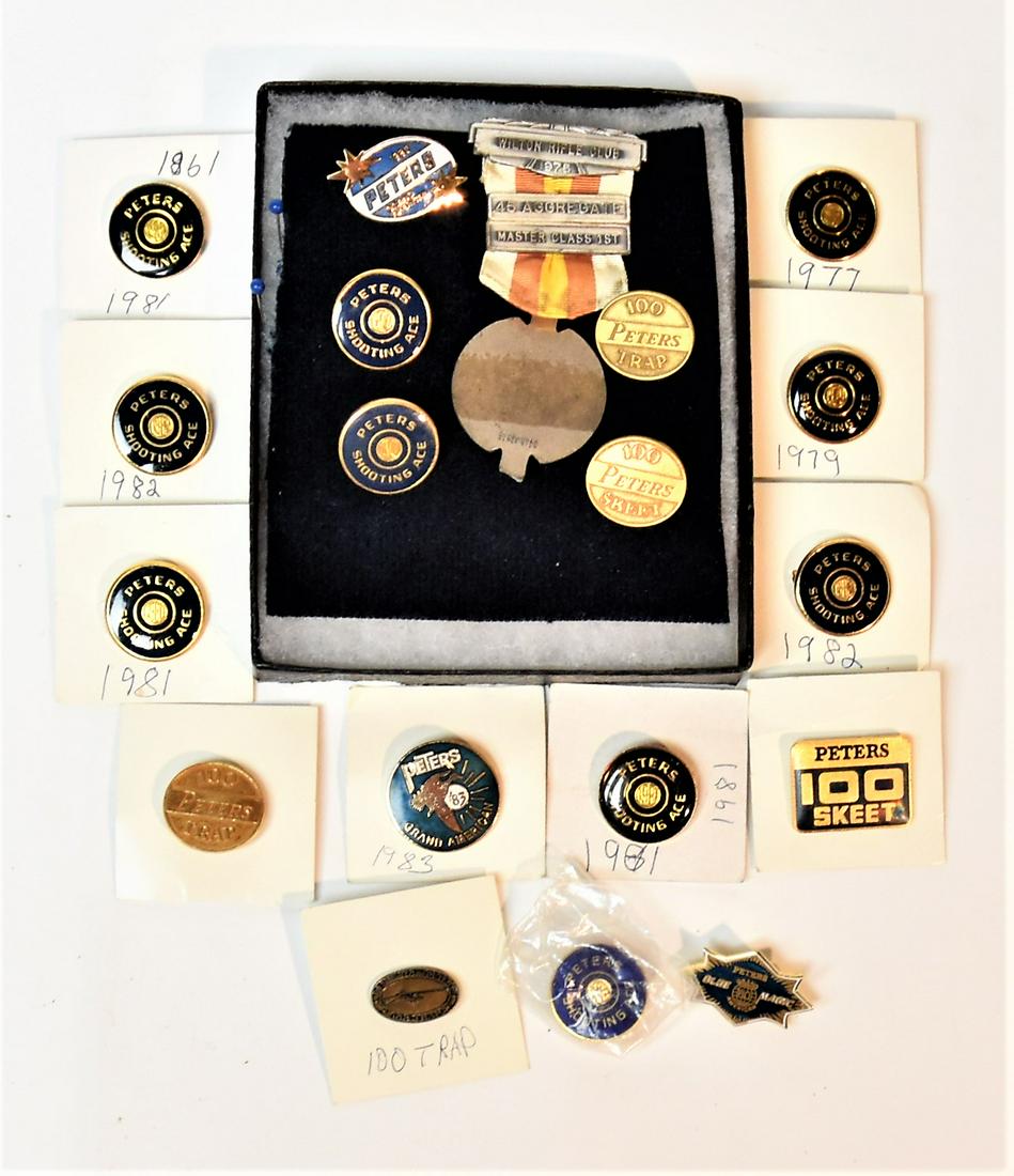 Peters Pinbacks Plus: Lot of 19, including 10 enameled pinback in two styles of Peters Shoot Ace, circa 7/8” diameter; plus three oval brass pinbacks with 100/Peters/ Skeet (2) & Trap; plus oval enameled pinback with