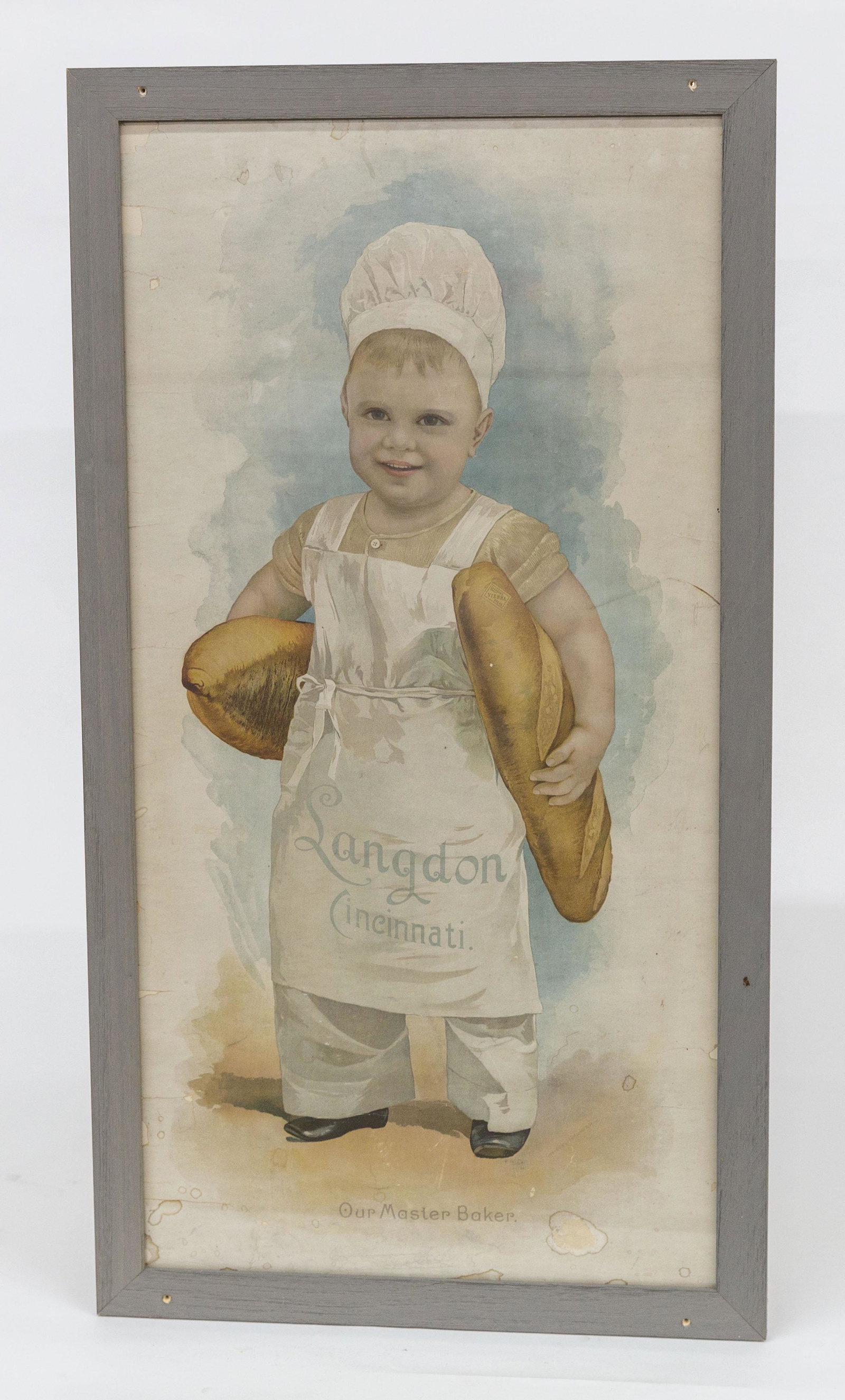 Cincinnati Langdon Bakery Chromolithograph: Image of toddler in bakers uniform holding two loffs of Vienna bread with Langdon Cincinnati on apron and Our Master Baker below, sight 14 ½ x 28 ½”, framed, 17 x 31”. Condit