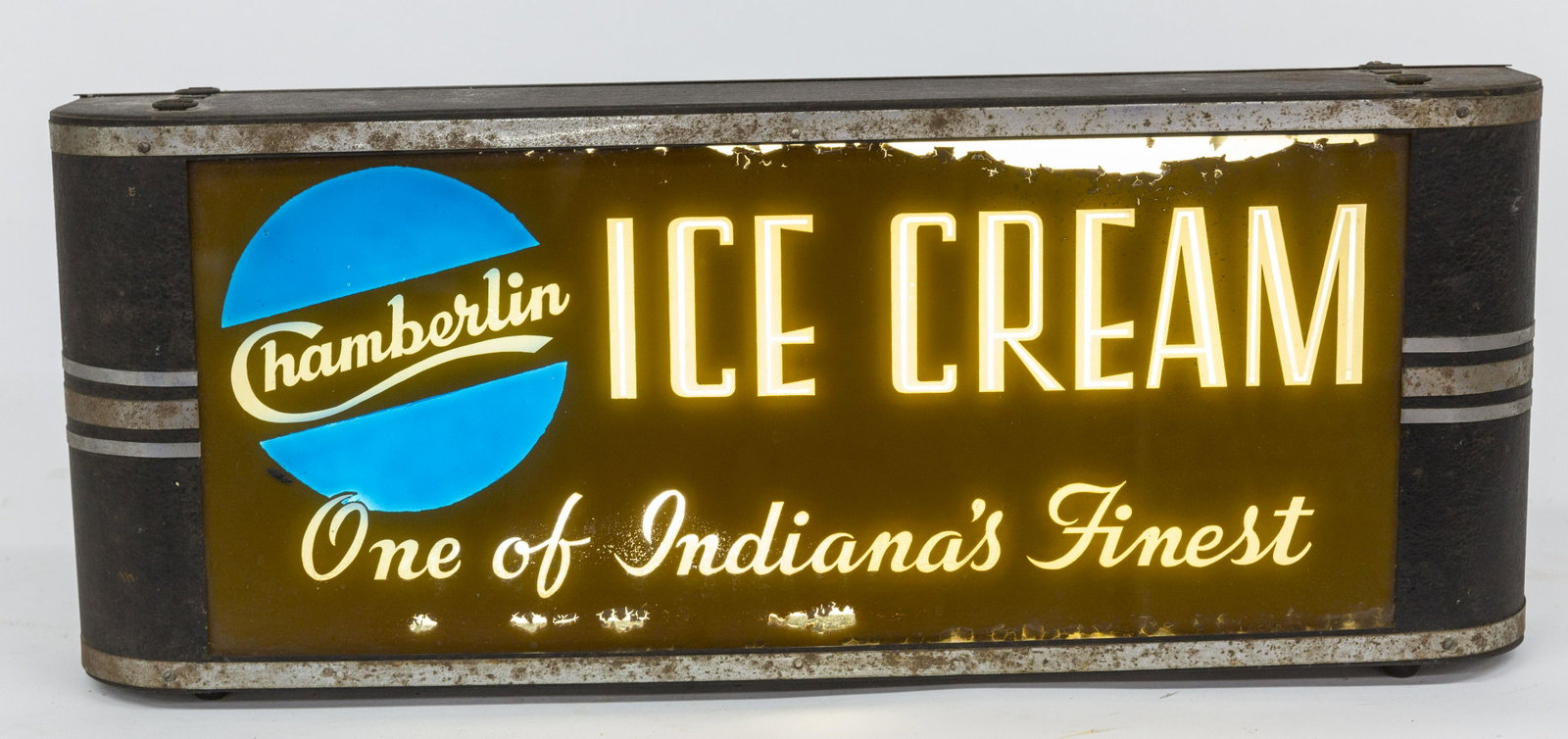 Lighted Chamberlin Ice Cream Sign: Art Deco black and chrome steel case with rounded ends, hanging with chromolithographed glass front on tan ground with white lettering as above and One of Indiana's Finest, 26 ½ x 4 ½ x 