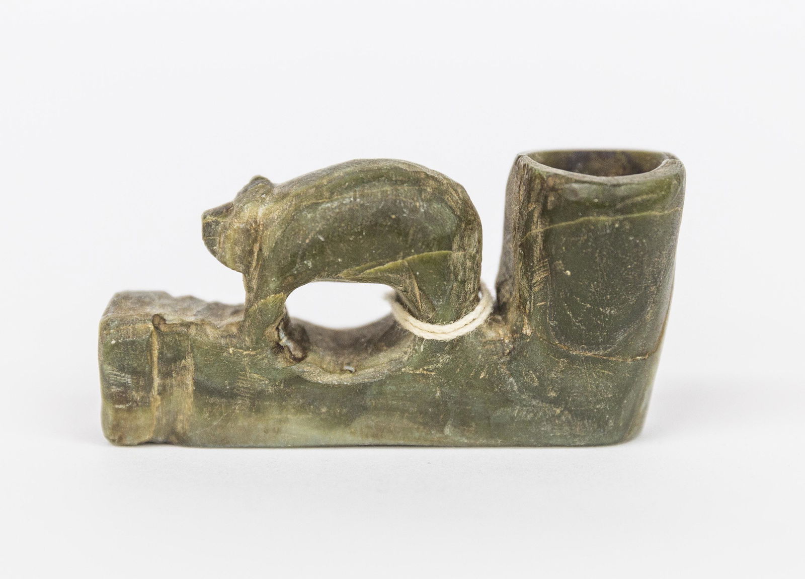 Native American Proto-Historic Effigy Pipe: Elbow type in steatite with walking bear on stem, old paper tag with inked inscription reading: Old Bear Pipe See Plate 105 Sun Circles & Human Hans; Cherokee Purchased 1924. 2 1/2" long x 7/7" wide x