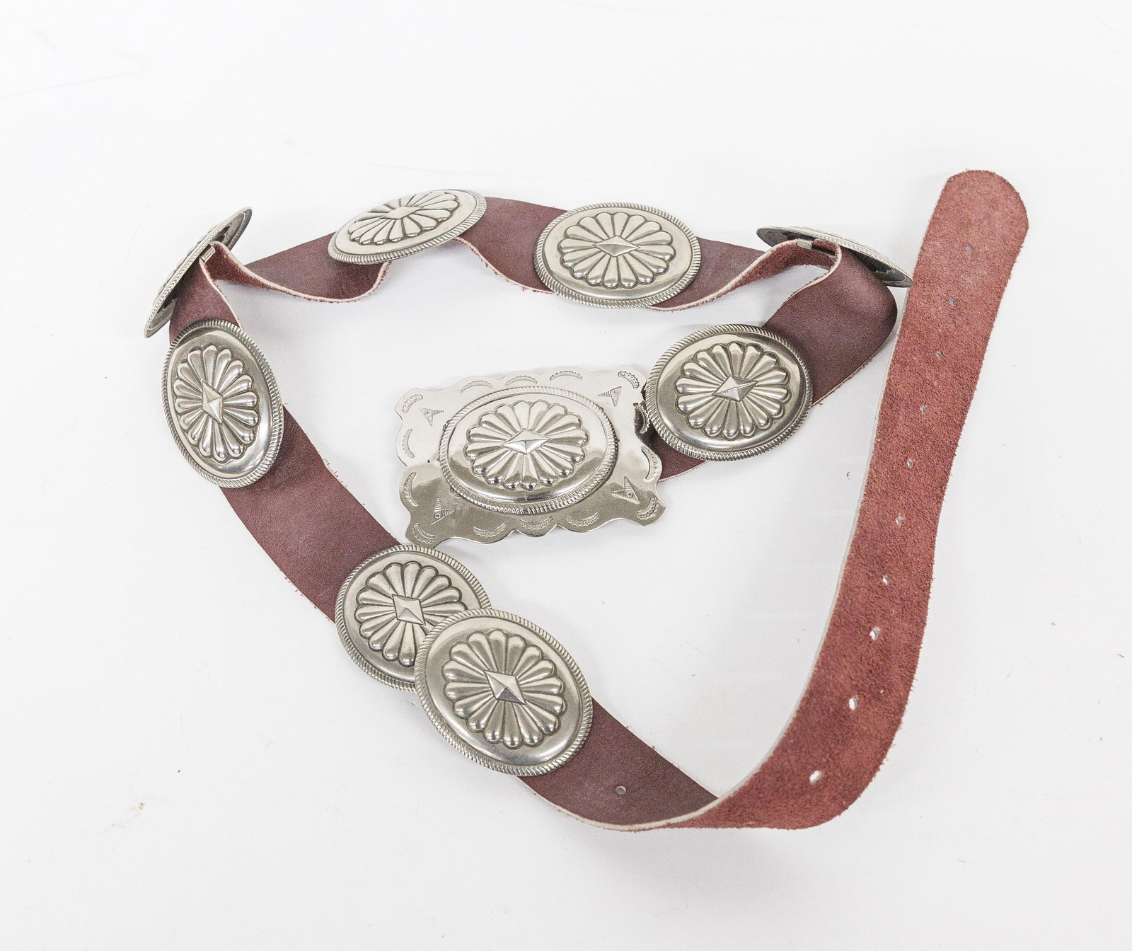 Navajo Style Belt: Nickle with eight conchos and belt plate on brown leather belt, 41" long. Condition Fine.