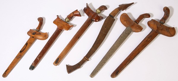 SIX ORNATE KRIS AND TRIBAL EDGED WEAPONS: All 19th Century with wood scabbards one with silver covered scabbard, from 15" to 22" in length.