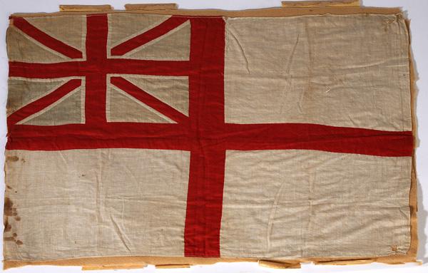 19TH CENTURY BRITISH WHITE ENSIGN FLAG: A printed British Naval ensign with early machine sewn margins, sewn to felt back with some light spots at hoist and two small holes in fly. 22" x 30".