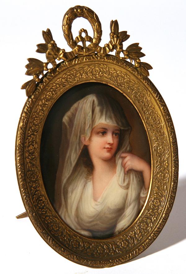 SIGNED WAGNER PORCELAIN PLAQUE: A lovely handpainted plaque of young lady. Signed "Wagner" lower right. In ornate gold frame. Good condition. 3 1/2" x 2 3/4".