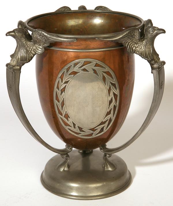 PAIRPOINT COPPER & PEWTER 3-HANDLED LOVING CUP: Decorated with three spread winged eagles, tri-fol feet on domed base. Marked with "P" in diamond and "Pairpoint Mfg. Co. B3338-1/2". 7.5" dia. X 8.5" high.
