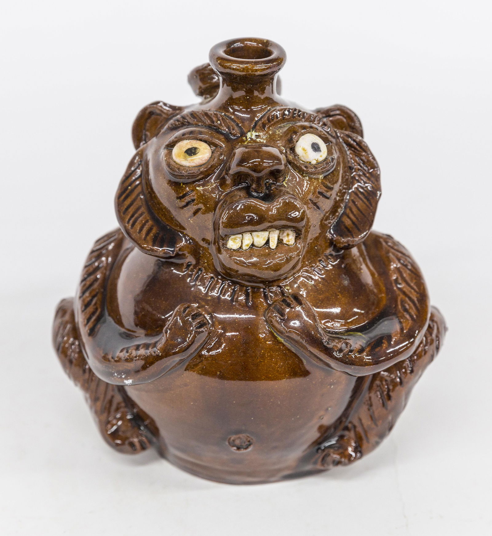 Albert Hodge Monkey Jug: Albany glazed redware with applied porcelain teeth and eyes, sgraffito inscription on rear reading: Like The Monkey I Work For Peanuts Albert Hodge Vale, N.C., with tail as handle, 7" diameter x 8 1/2