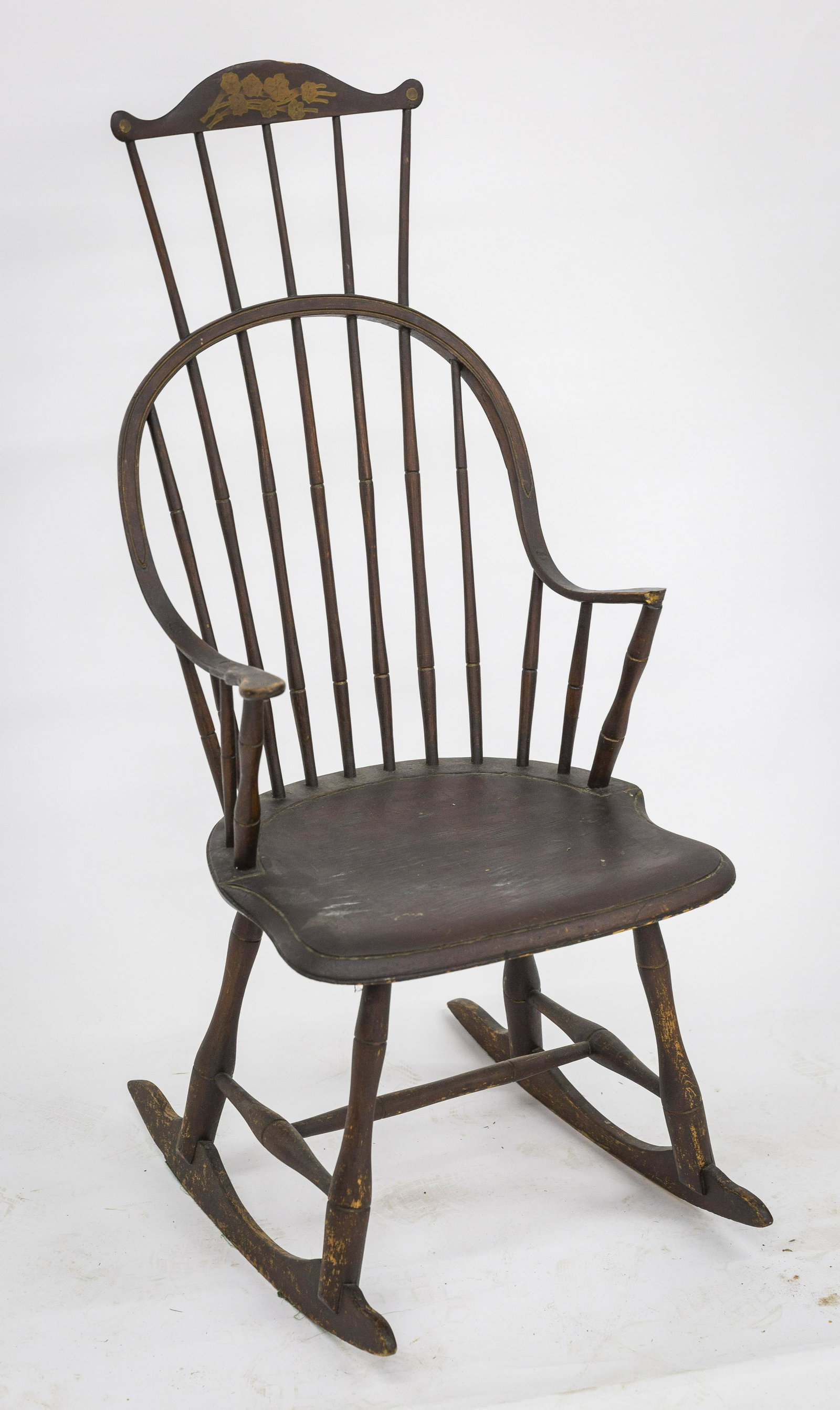 Comb-back Continuous Arm Windsor Rocker: In period red painted finish, mixed woods with saddle seat, cut-out comb crest yellow painted flowers and five turned spindles, arch back/arms with 11 bamboo turned spindles and matching arm supports,