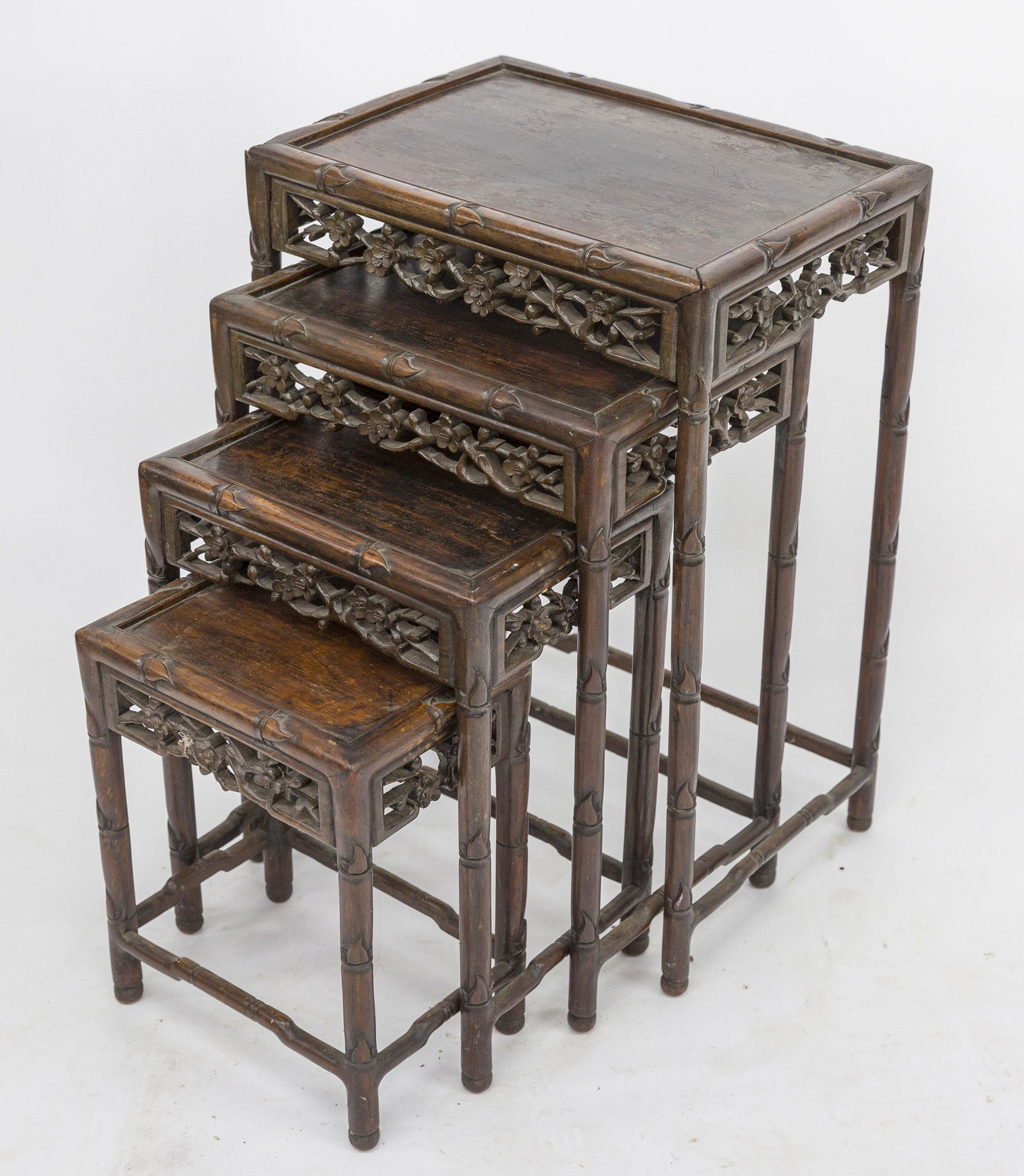 Chinese Teak Nested Tables: Circa 1890, nest of four rectangular with bamboos turned legs and stretchers, pierce carved floral aprons, largest is 14 x 20 x 28" high; smallest is 12 /2 x 9 x16" high, all in original finish. Condi